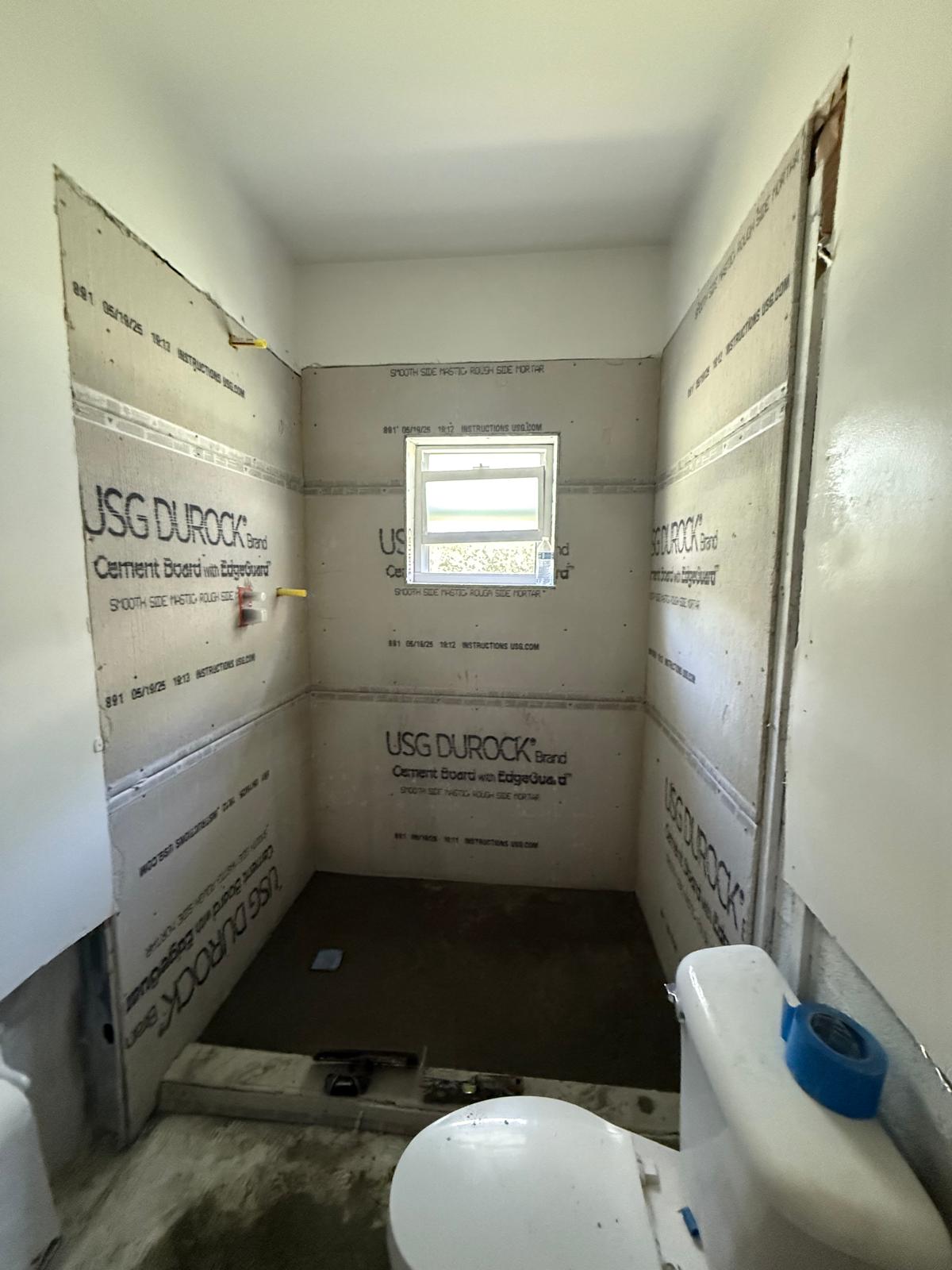 Bathroom in progress — waterproofed Durock cement board ready for tile