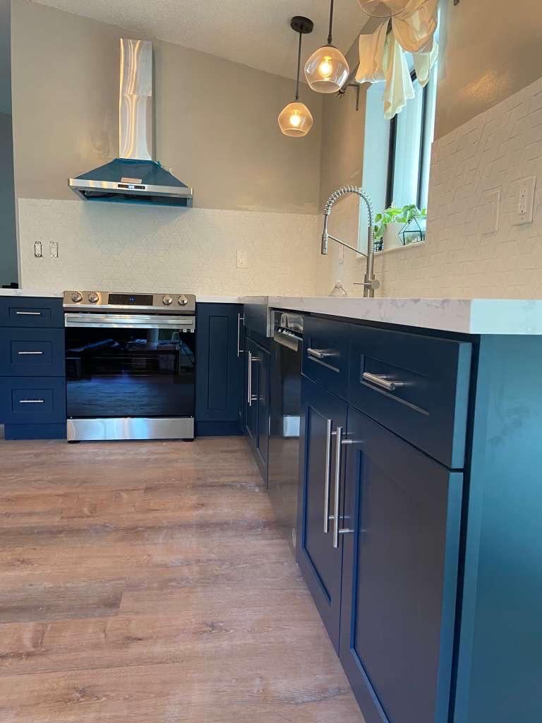 Navy shaker kitchen with stainless hood and quartz counters