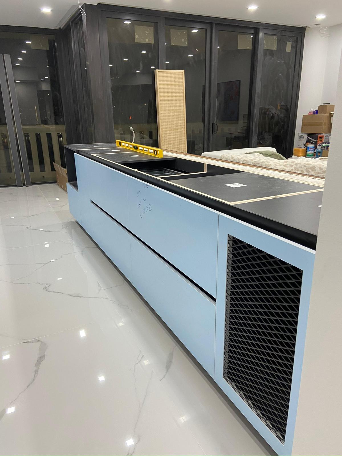 Sky-blue lacquer island with porcelain counters, evening view