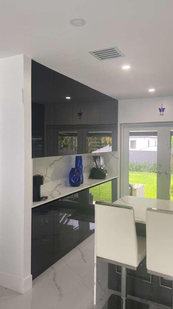 Black high-gloss cabinetry adjoining dining area