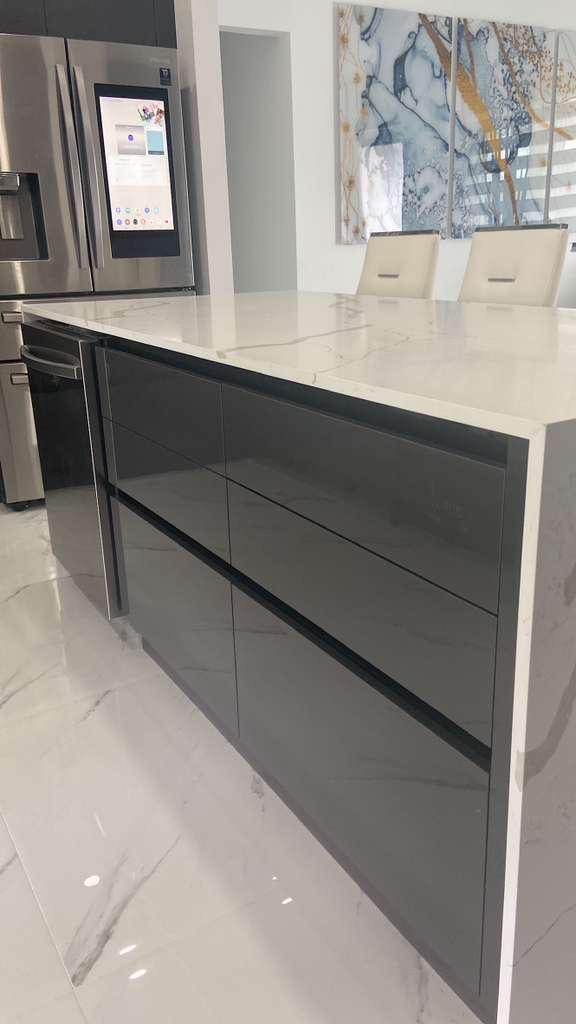 High-gloss grey island with calacatta waterfall counter